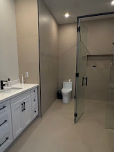 Finished bathroom with new vanity, toilet and glass shower enclosure