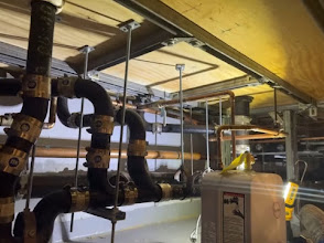 Newly installed copper pipes and mixing valve mounted on a ceiling rack